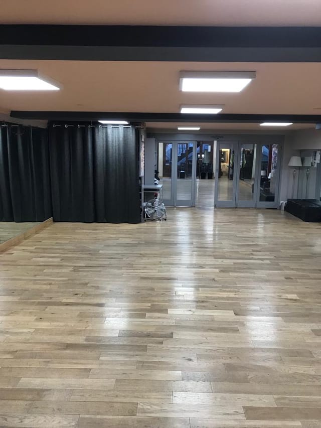 Versatile event space with polished floors, ideal for workshops and social gatherings.