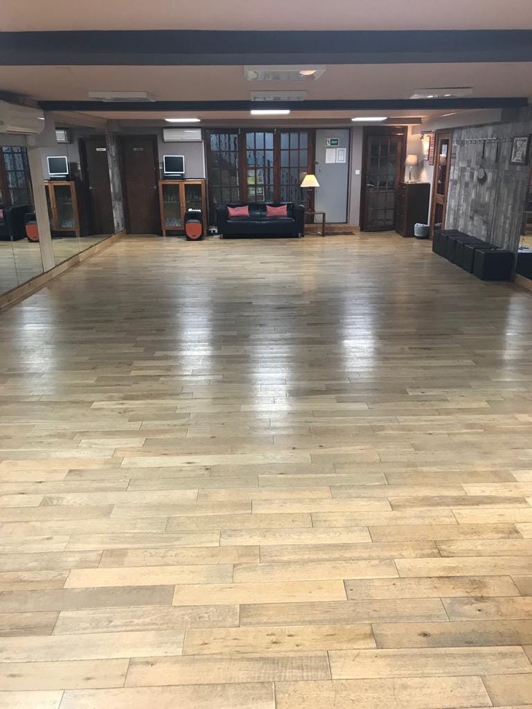 Spacious event venue with polished wooden floors, ideal for workshops and gatherings.
