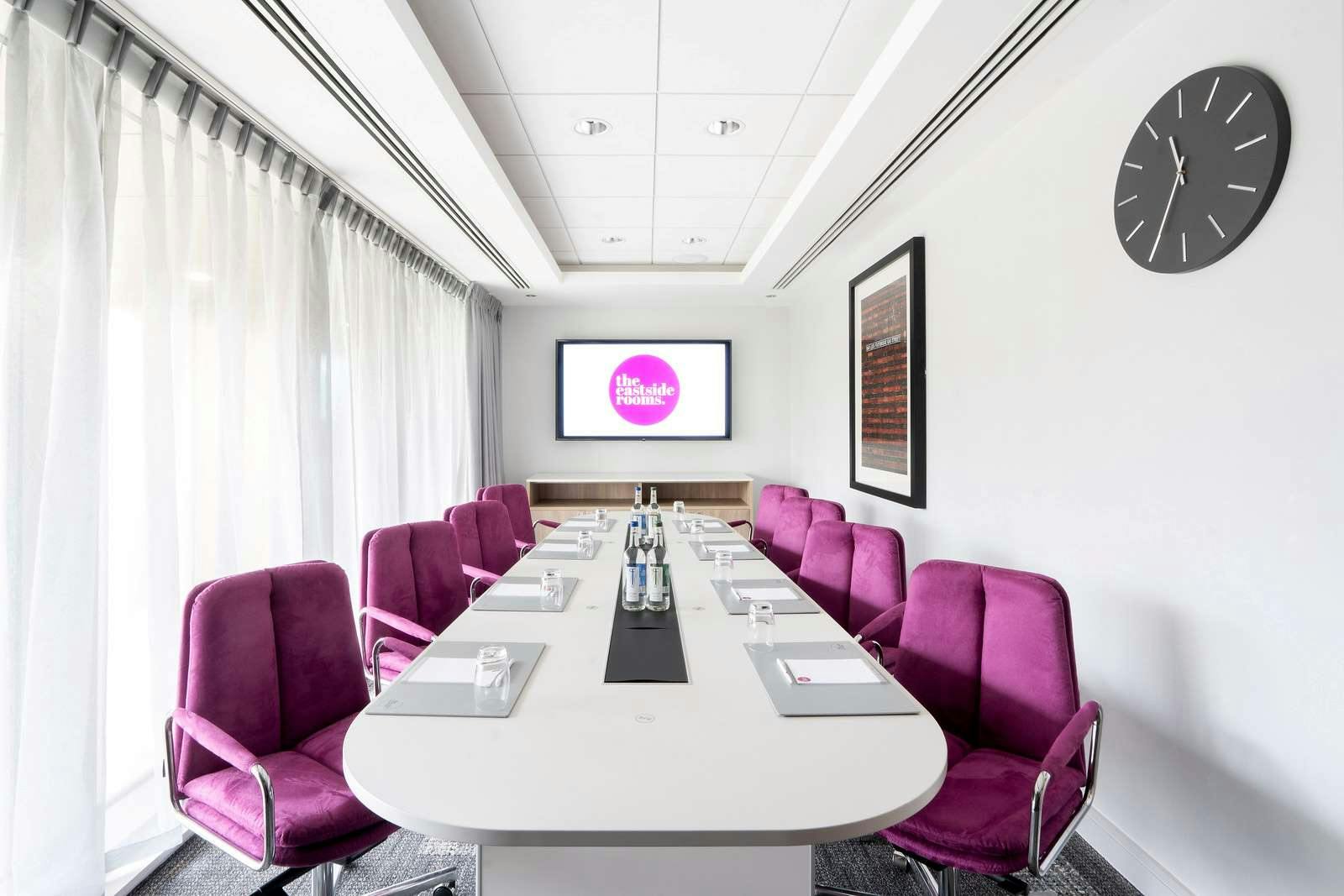 Modern Boardroom One with sleek table and vibrant chairs for meetings and brainstorming.