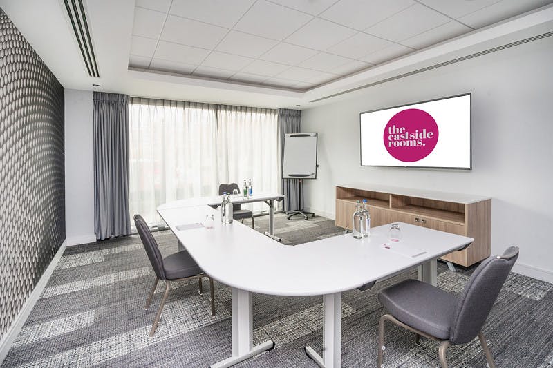 Modern meeting room with U-shaped table, ideal for professional gatherings and events.