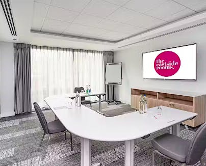 Modern Meeting Room Six with white table, ideal for corporate events and workshops.