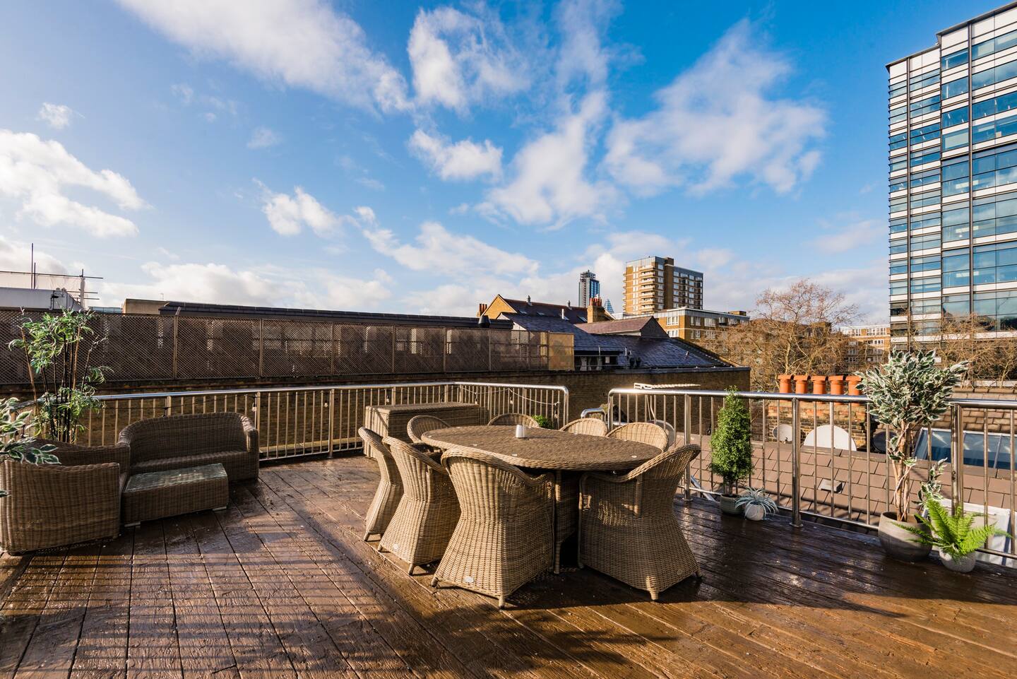 Spacious rooftop terrace in Shoreditch for events, featuring stylish wicker furniture. - Banner