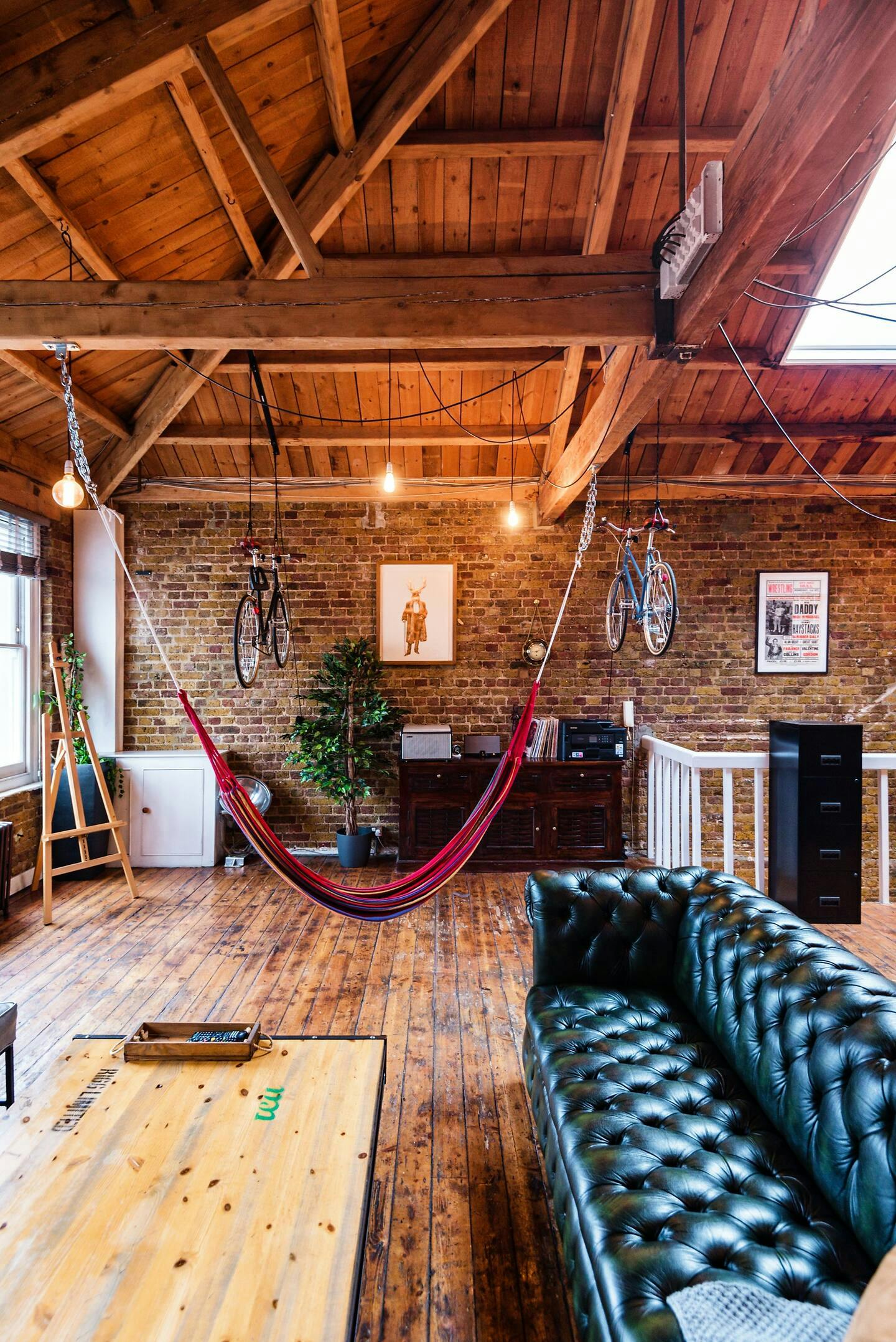 Creative meeting space with hammock, exposed brick, ideal for filming and events.