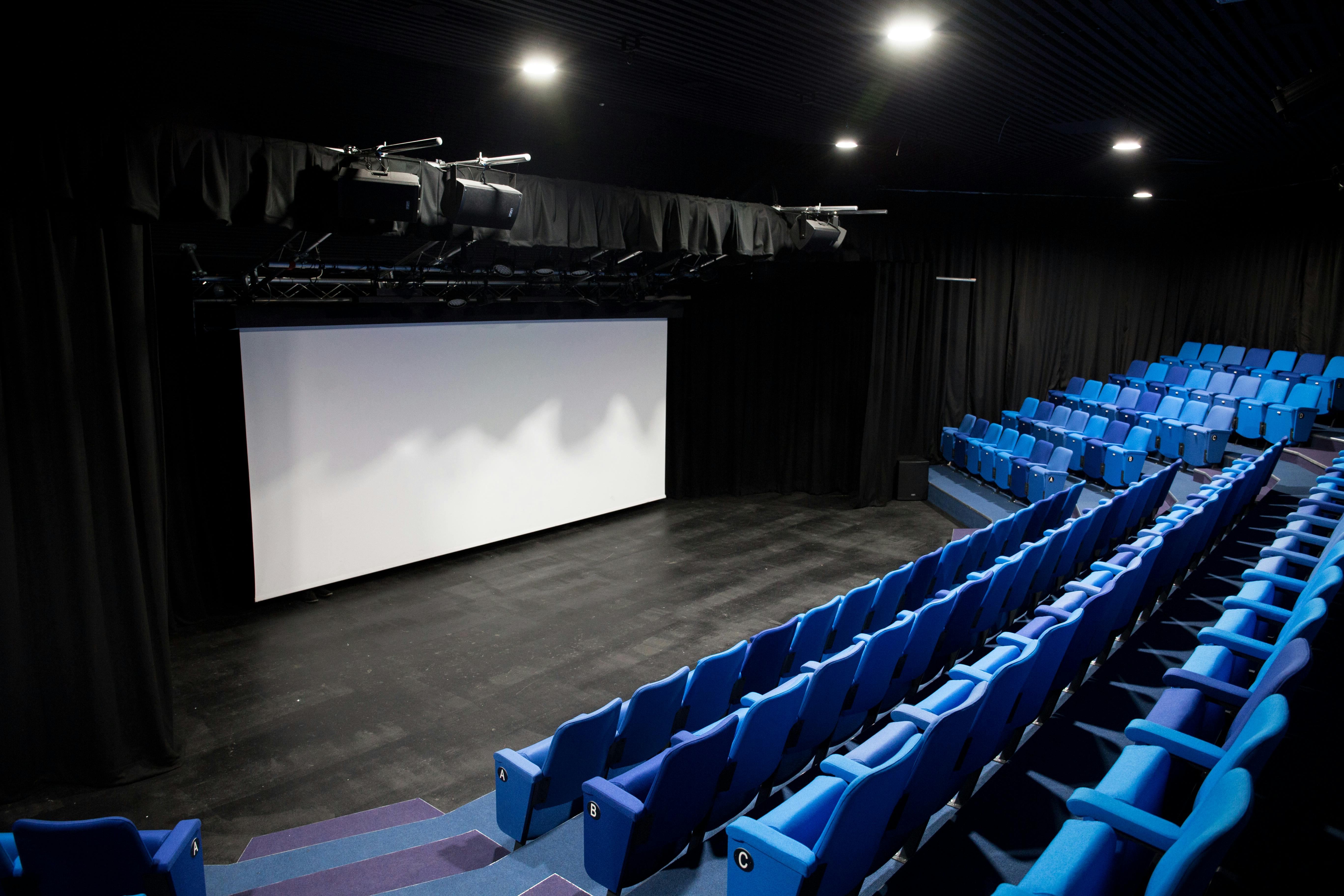 Chesterfield College theatre with tiered blue seating for conferences and performances.