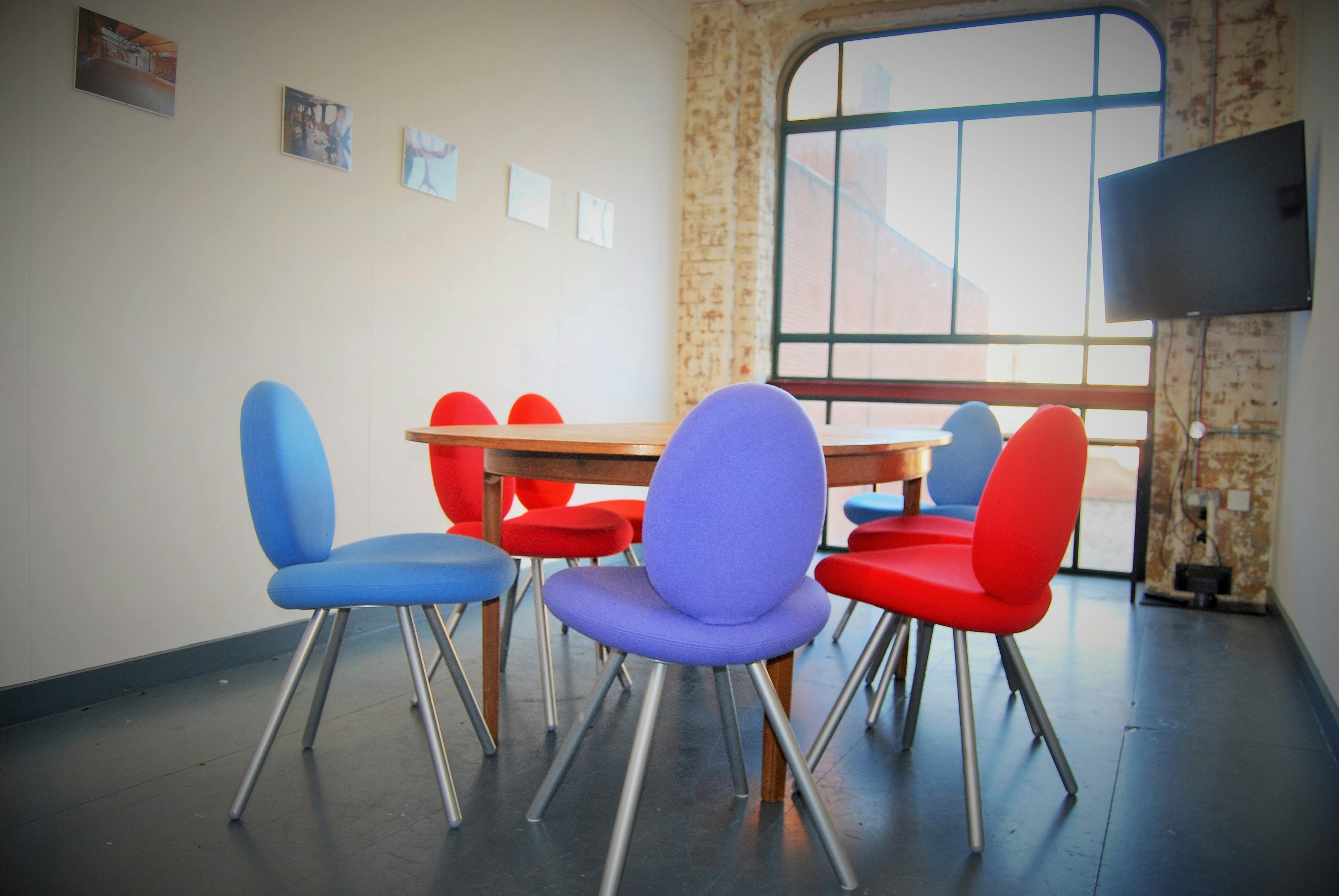 Modern meeting room with round table and colorful chairs at Arcola Theatre & Bar.