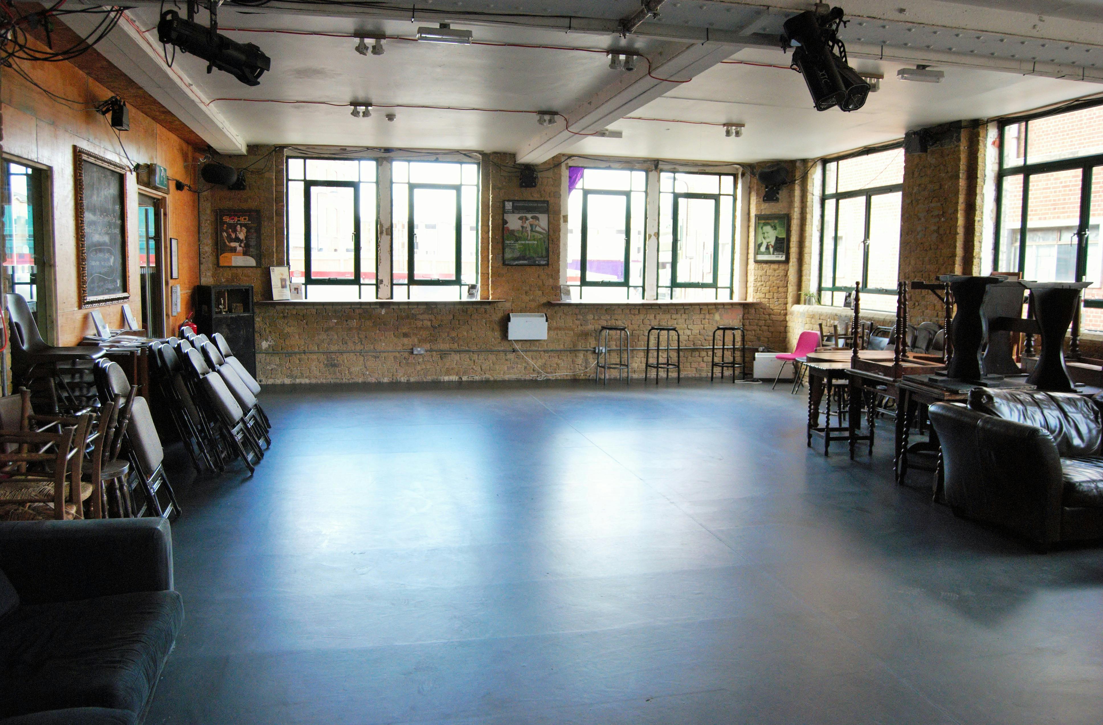 Versatile event space with natural light and exposed brick for meetings and gatherings.