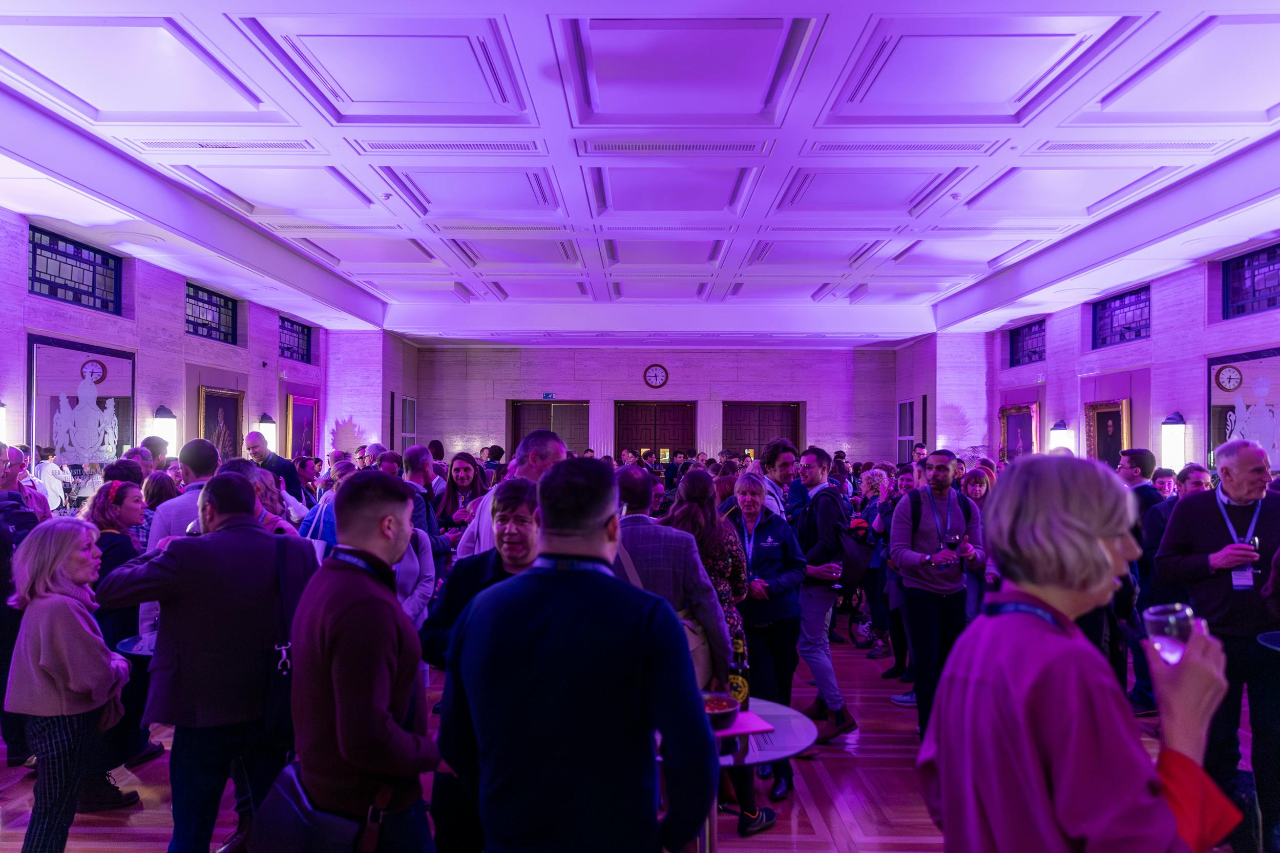 "Networking event at MacMillan Hall, University of London, with elegant purple lighting."