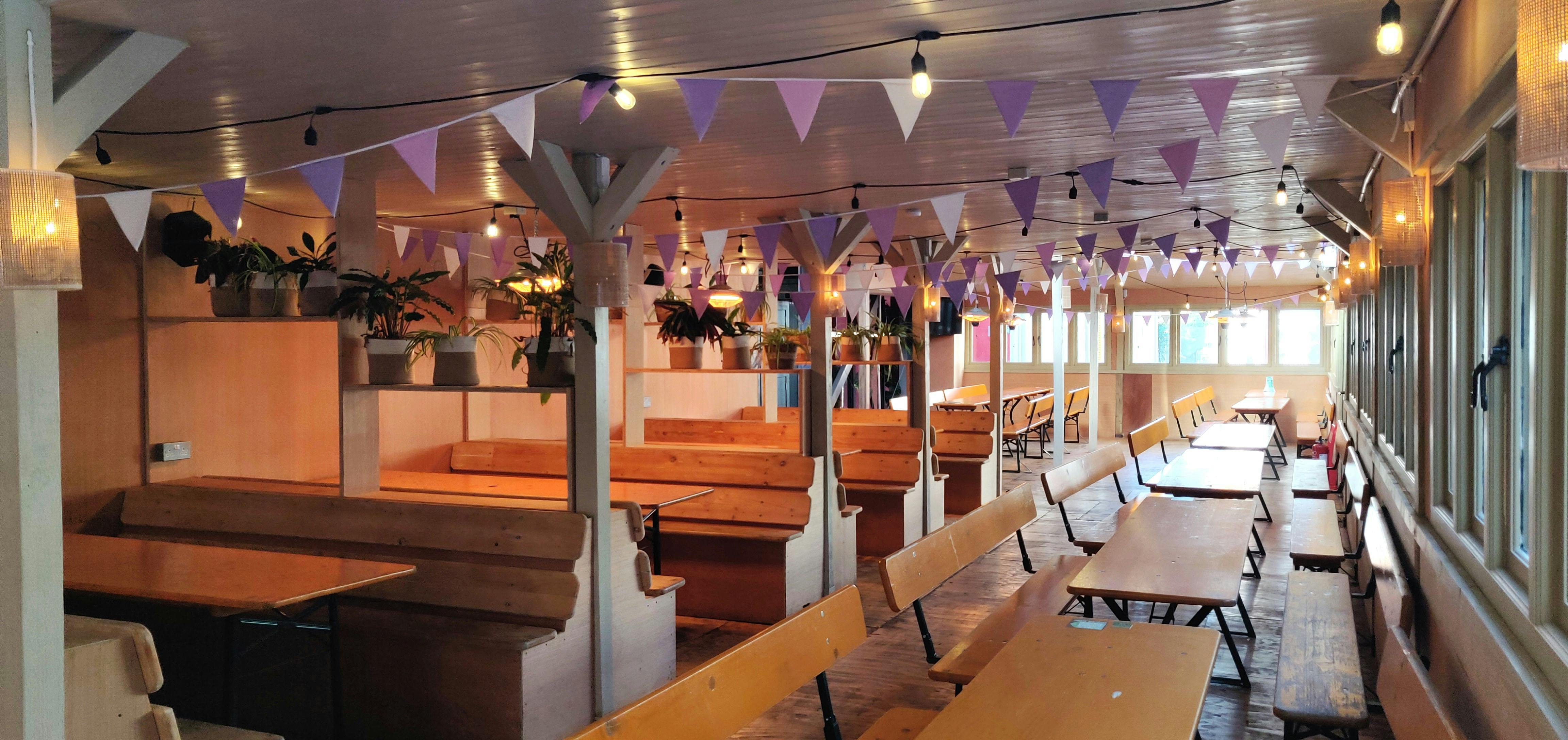 Log Cabin in Hackney Bridge: versatile event space with colorful bunting for gatherings.