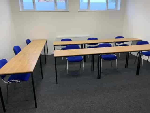 Meeting Room 3 at Bridge School: U-shaped tables and blue chairs for engaging discussions.