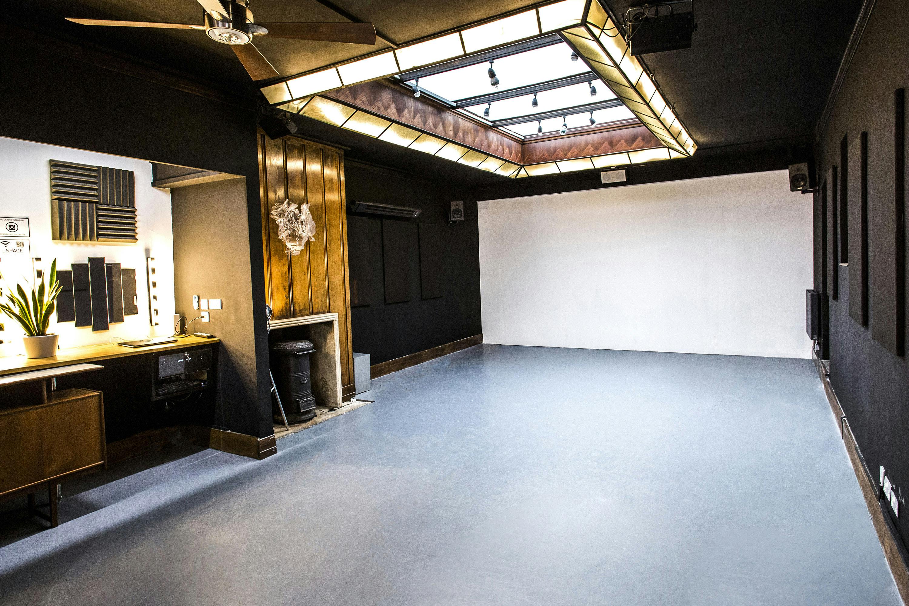 Versatile event space with skylight, ideal for workshops and gatherings.