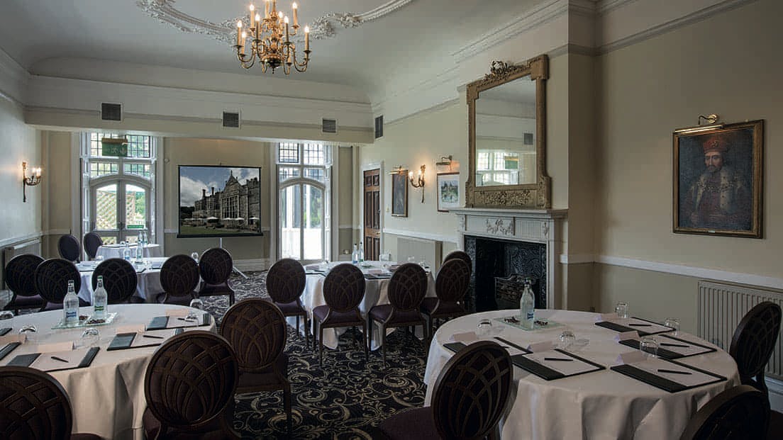 Sophisticated meeting room at Rhinefield House Hotel with elegant round tables for corporate events.