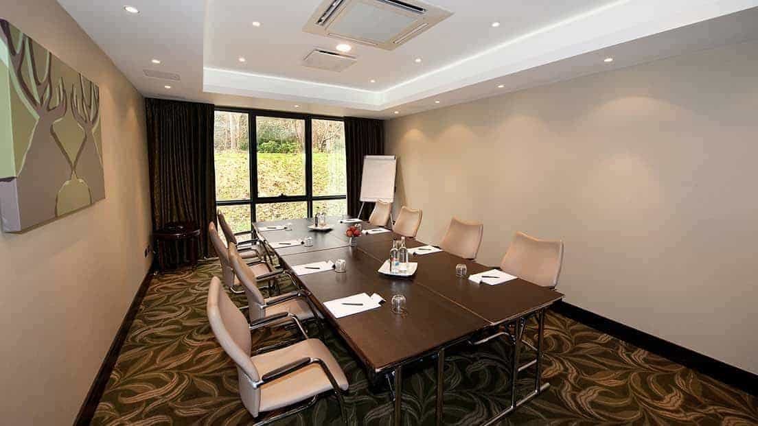 Brockenhurst meeting room at Rhinefield House Hotel with large conference table, ideal for events.