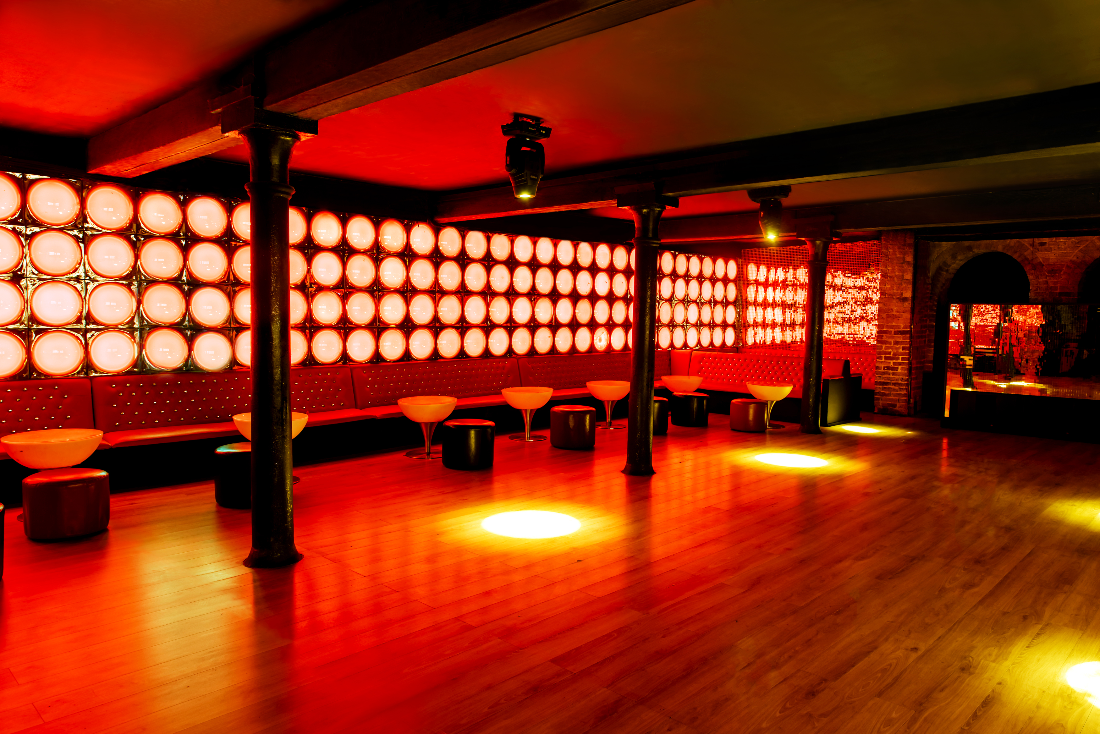Vibrant La Pollera Colora event space with red lighting, ideal for parties and networking. - Banner