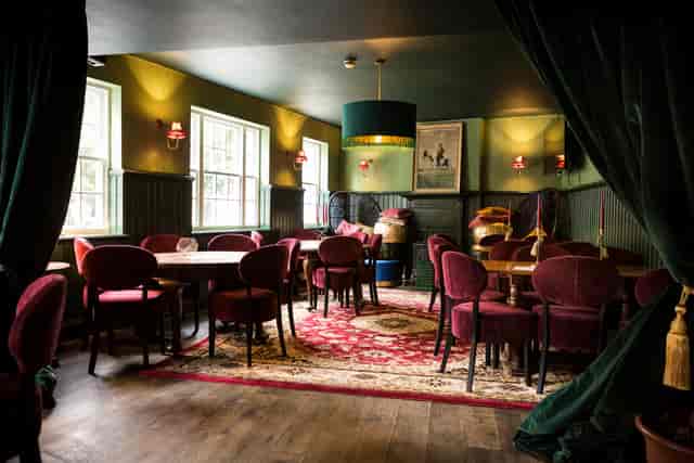 Cozy meeting space at Biddy Mulligan's Olympia with green walls, ideal for gatherings.