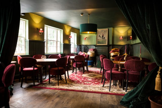 Cozy meeting space at Biddy Mulligan's Olympia with green walls, ideal for gatherings.