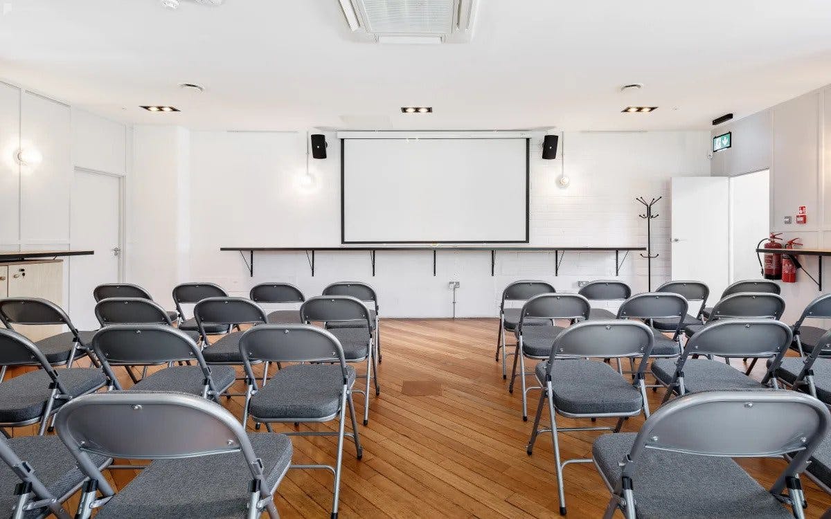 Versatile conference space with gray chairs, ideal for meetings and events.