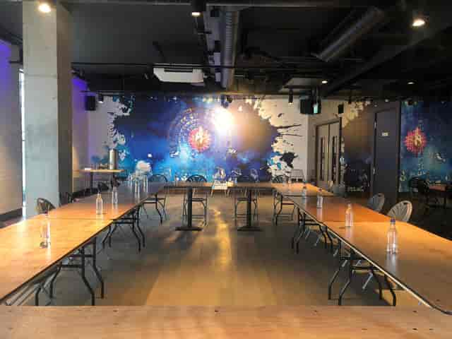 Versatile meeting space in OmStudio with vibrant mural for collaboration and creativity.