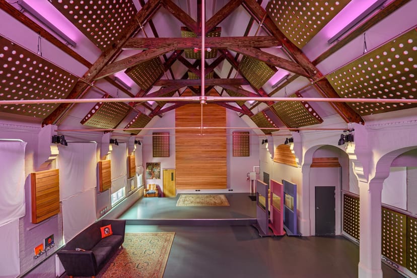 Versatile event space with exposed beams, ideal for meetings and creative gatherings.