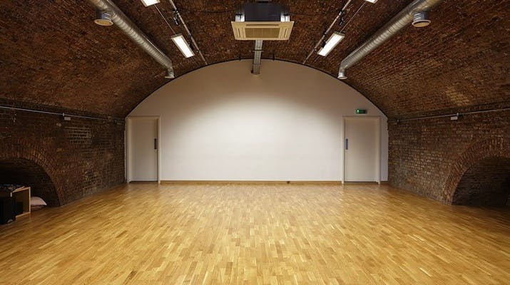 Versatile event space with arched ceiling, ideal for workshops and gatherings.