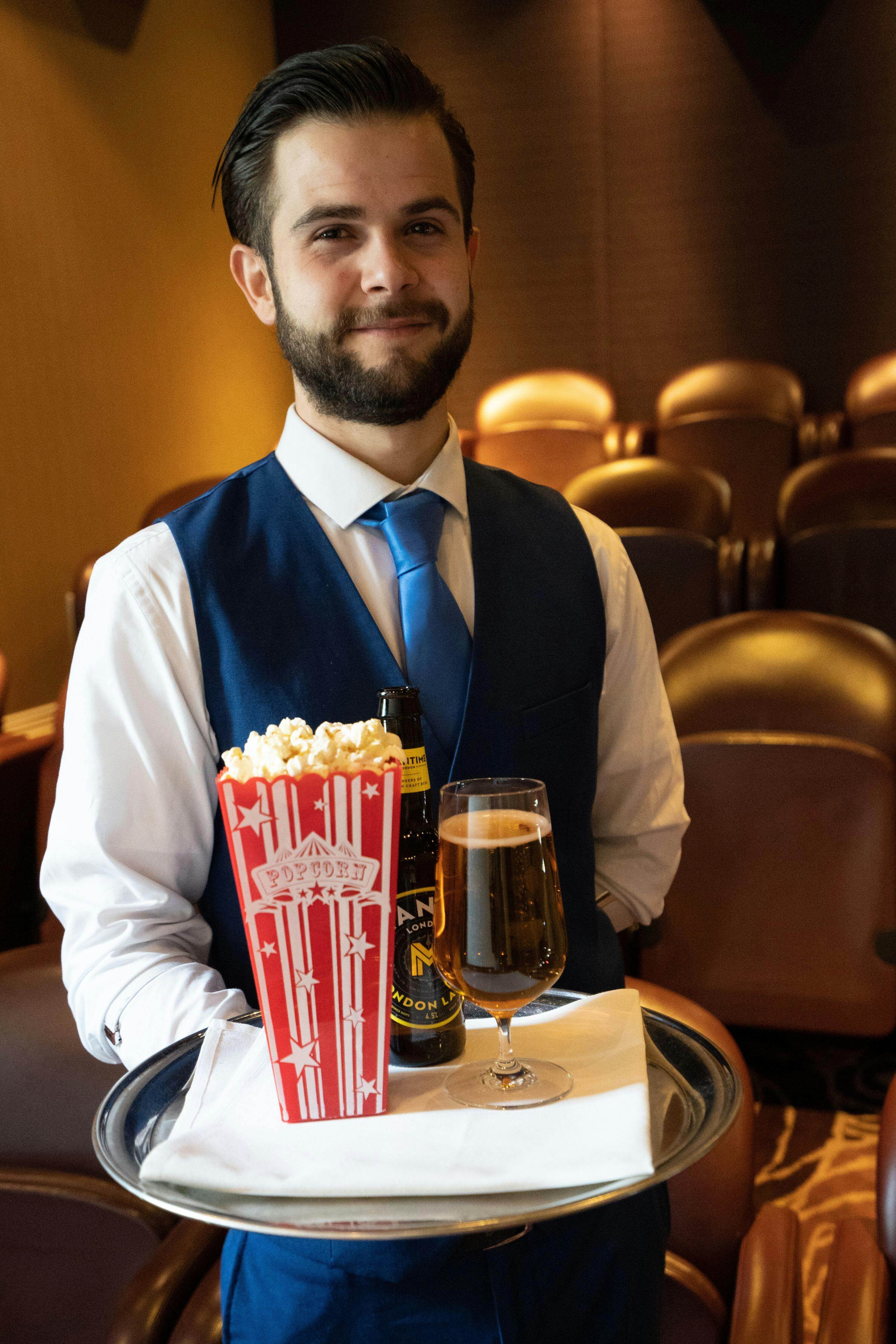 Professional staff member in formal attire at Upstage Mini Cinema, Reading event venue.