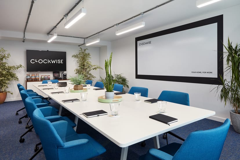 Modern meeting room with white table and blue chairs for productive events.