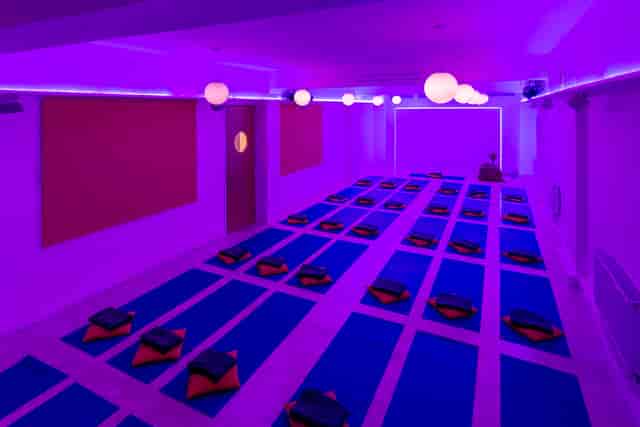 Serene yoga studio with purple lighting, ideal for wellness retreats and mindfulness workshops.