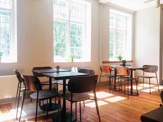 Bright cafe in Oxford House with wooden tables, ideal for workshops and meetings.