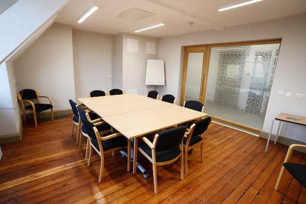 Settlement Room in Oxford House: bright meeting space with large table, ideal for collaboration.