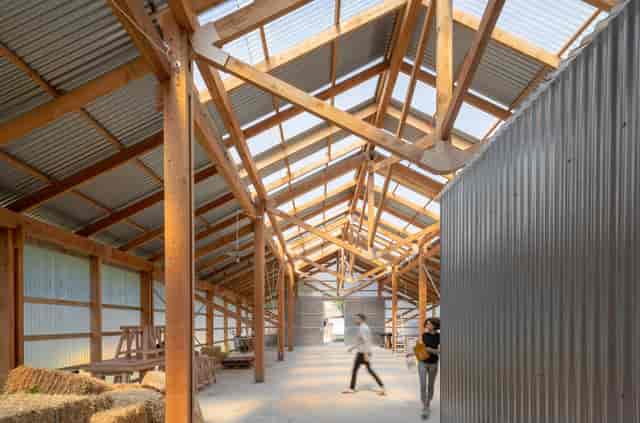 Spacious barn venue with wooden beams for corporate events and social gatherings.