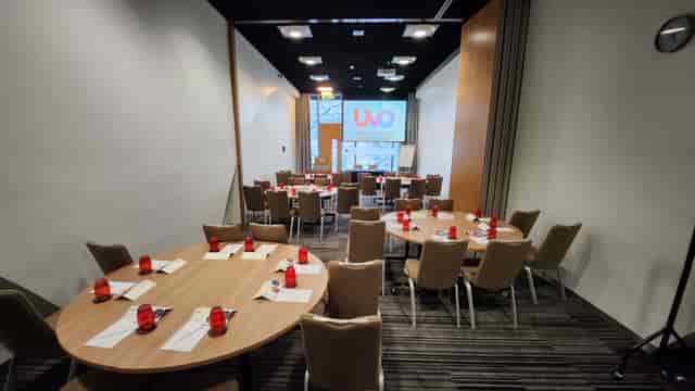 Meeting space LOB 103 with round tables and red accents for workshops and seminars.