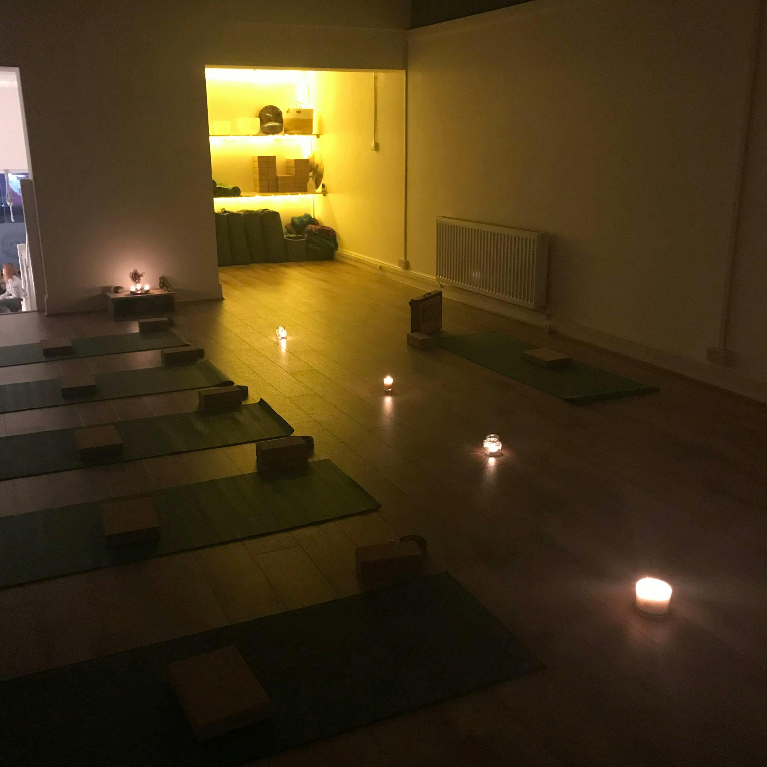 Serene yoga studio with mats and candlelight for mindfulness events and wellness retreats.