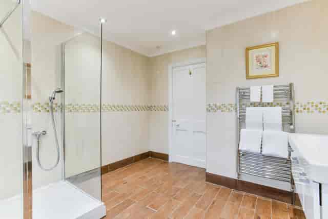 Modern bathroom at Kingswood Manor, featuring a glass shower for events and meetings.