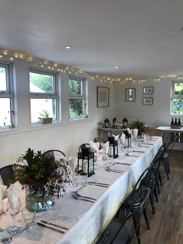 Elegant event space with long table, flowers, ideal for gatherings and meetings.