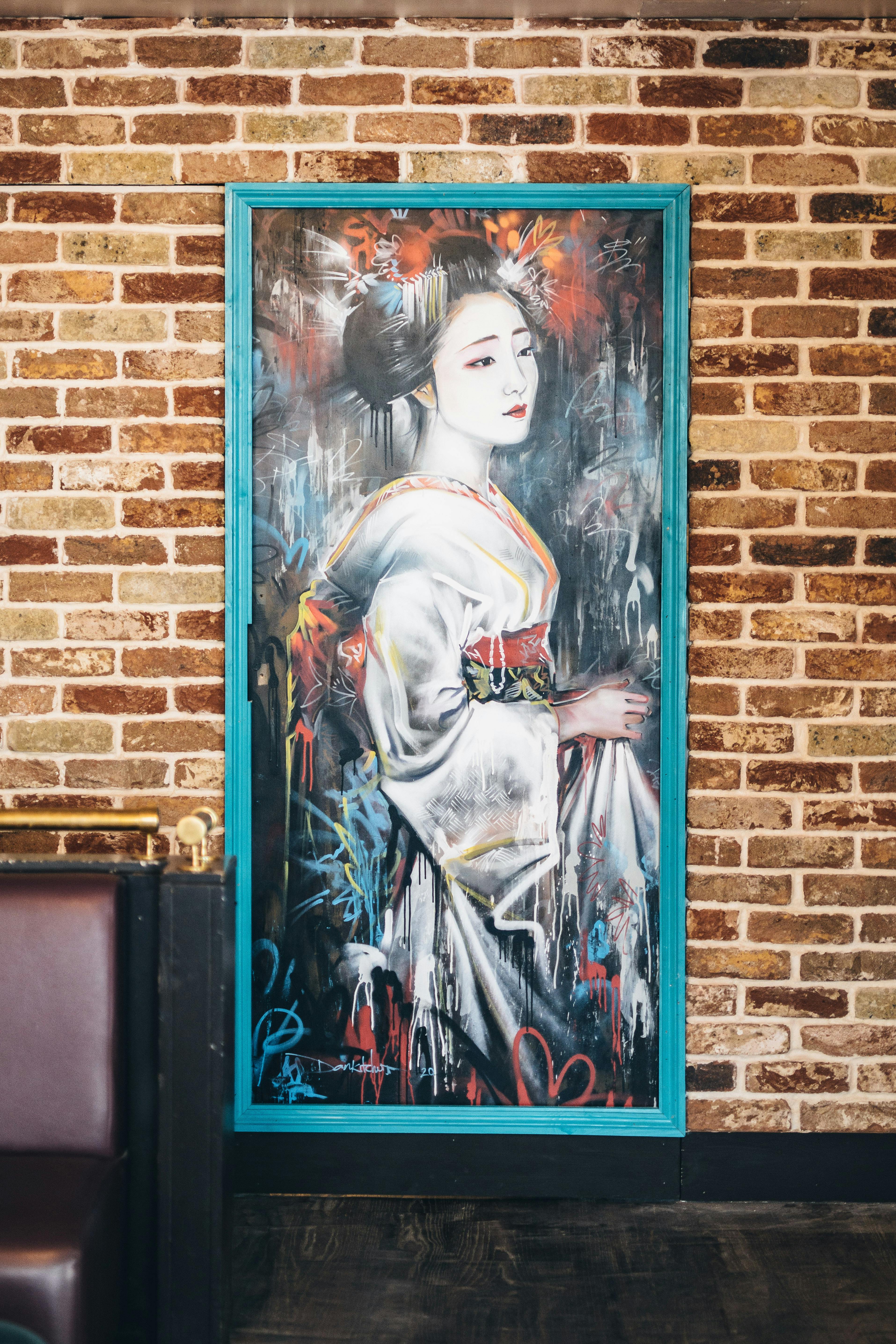 Geisha artwork on brick wall at Callooh Callay Chelsea, ideal for events and decor.