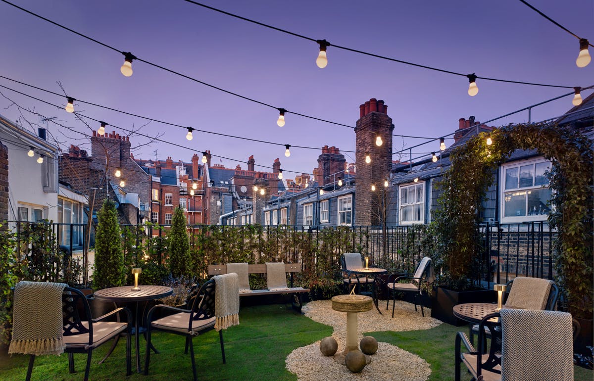 Rooftop venue at Holmes Hotel London with string lights, ideal for gatherings and events.