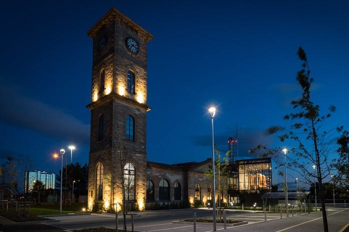 Illuminated Clydeside Distillery venue with clock tower, perfect for evening events.