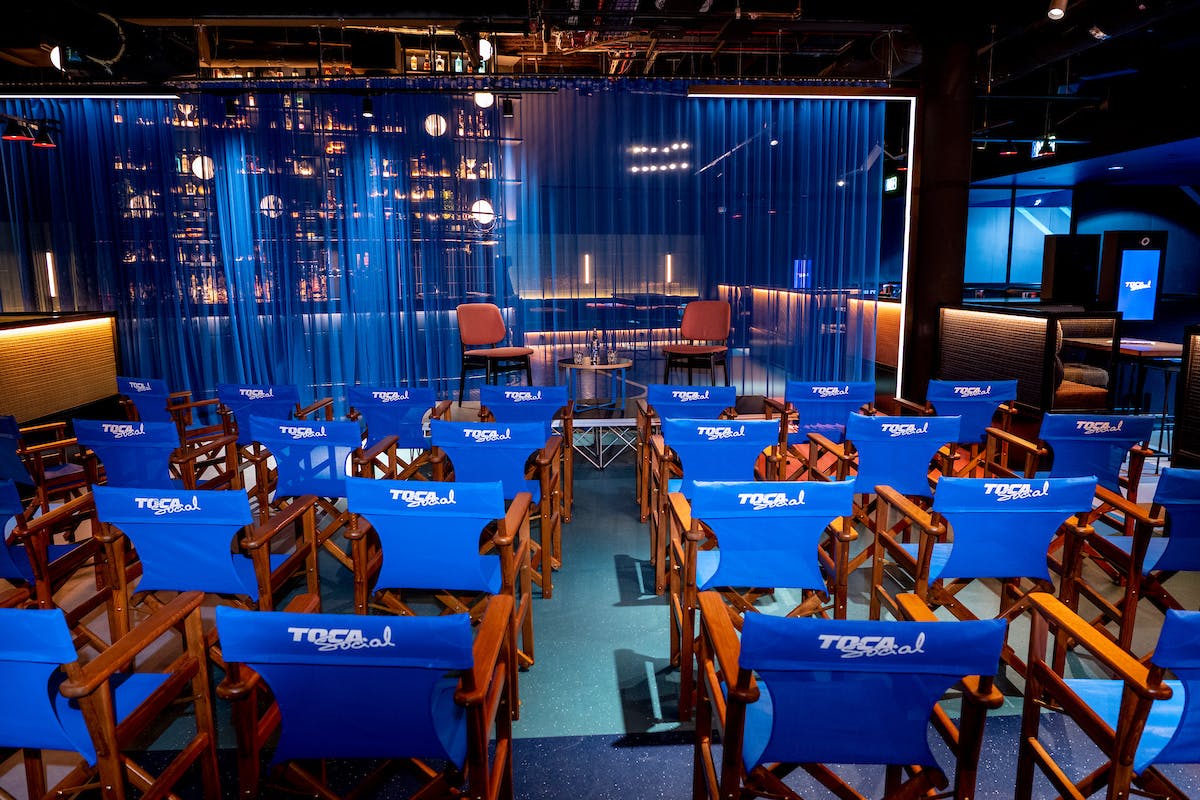 Corner Bar at TOCA Social, modern event space for presentations with blue backdrop.