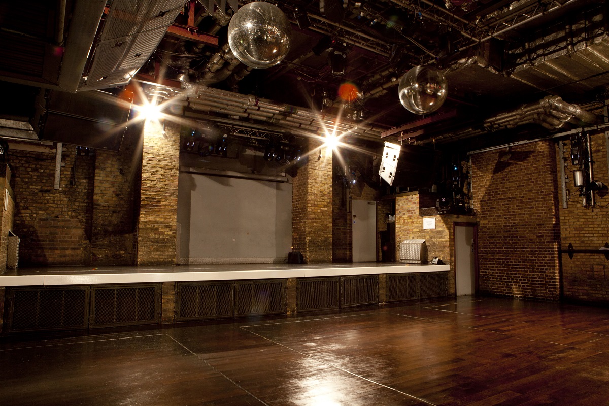 Versatile event space with spacious stage and polished wood floors for concerts and gatherings.