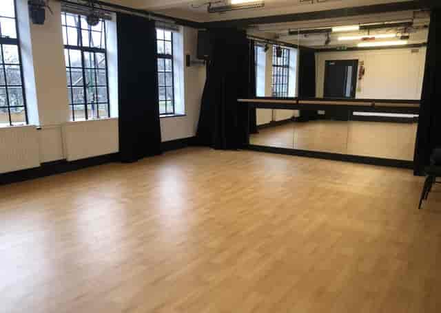 Versatile event space with mirrored wall, ideal for workshops and fitness classes.