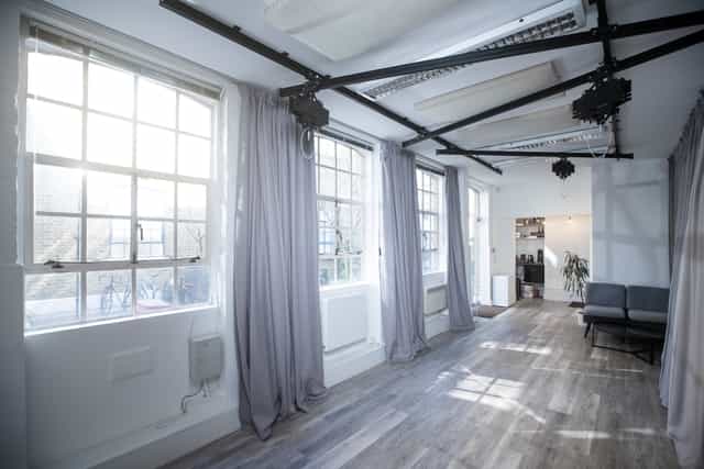 Bright event space with large windows for meetings and workshops at FOMO Studios.