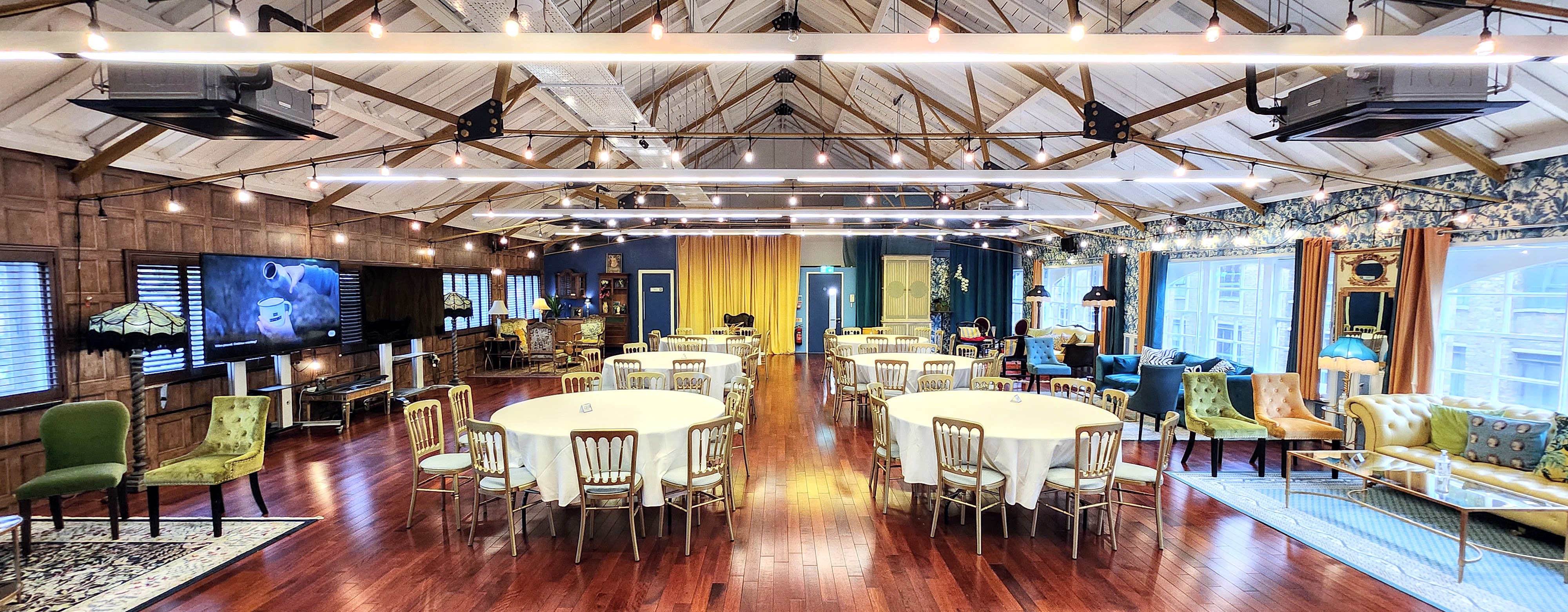 Versatile event space with round tables, ideal for meetings and social gatherings. - Banner