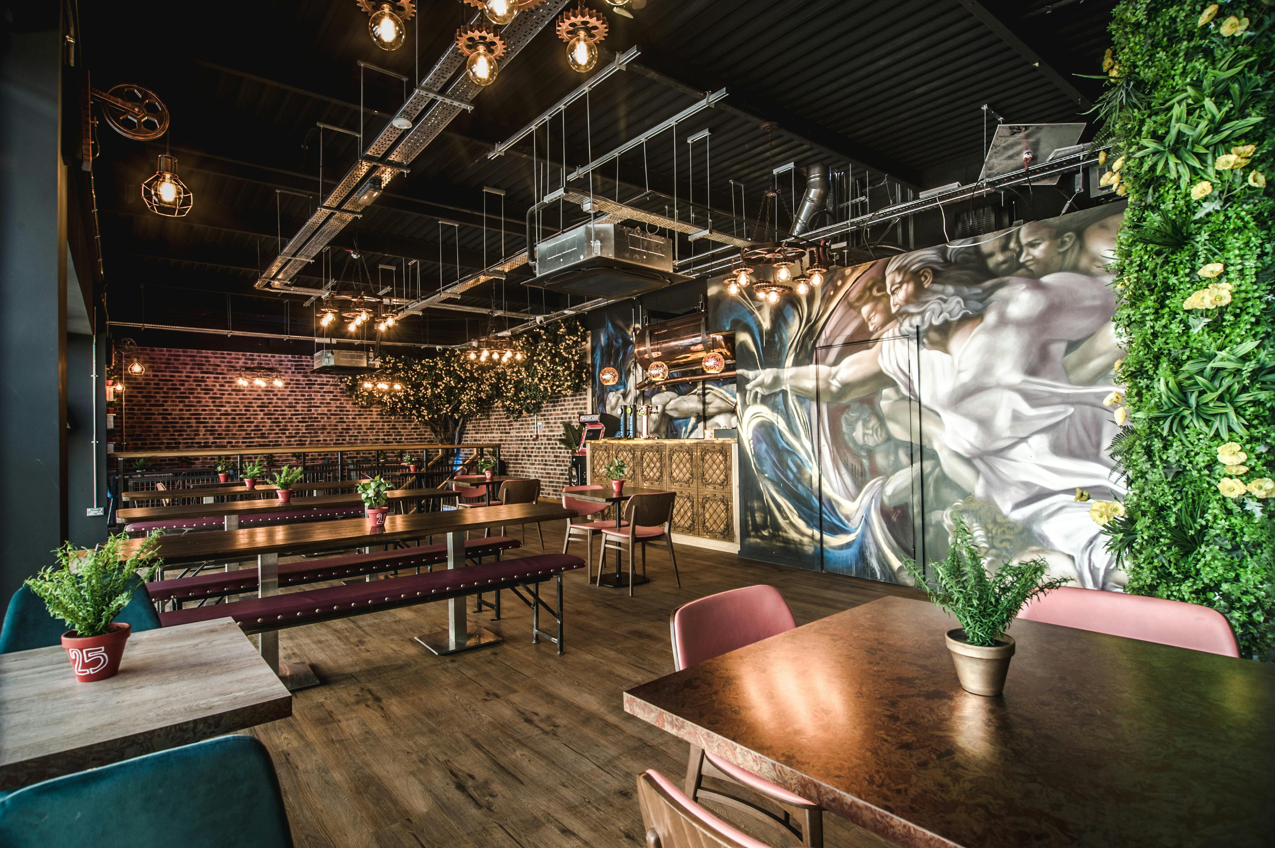 Stylish event space in Dough Dough Liverpool with vibrant mural and greenery.