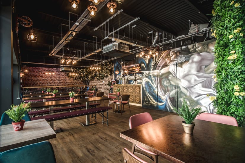 Stylish event space in Dough Dough Liverpool with vibrant mural and greenery.