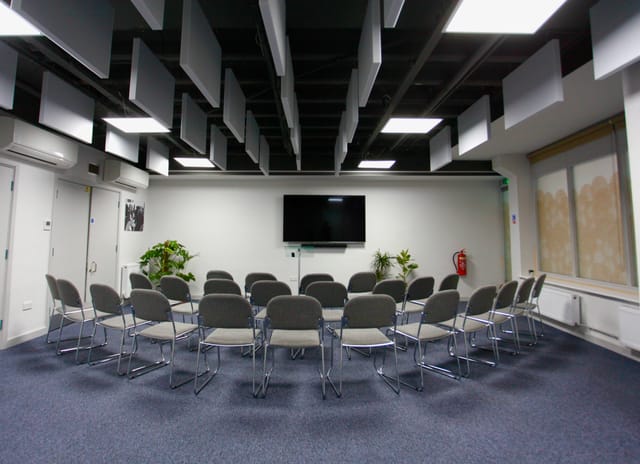 Meeting room at Neal Street Espresso with chairs and screen for workshops and presentations.