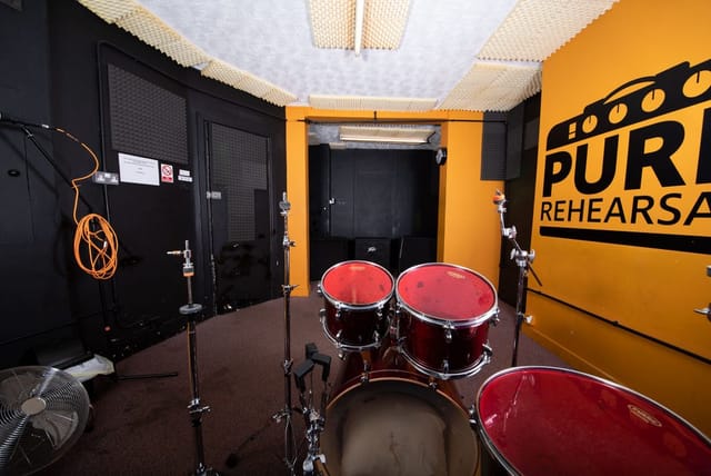 Rehearsal space with drum set and soundproofing for music events at Pure Rehearsal Studios.