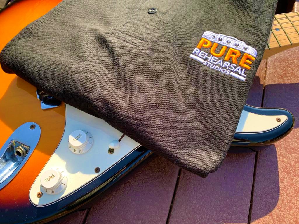 Branded fleece on guitar at Pure Rehearsal Studios, ideal for creative events and meetings.