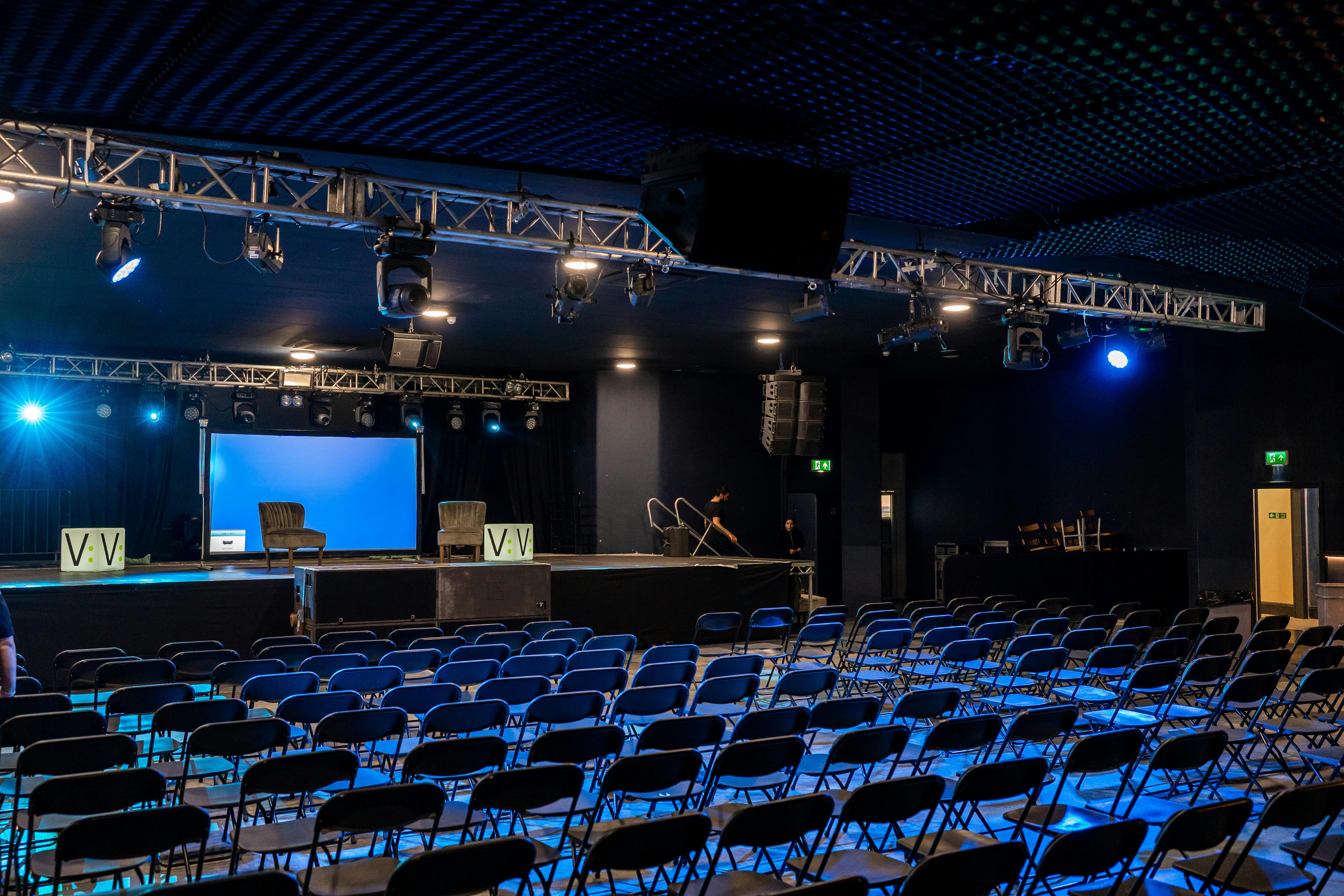 Theatre in EartH event space with stage, lighting, and seating for presentations.