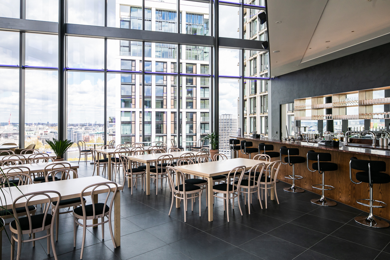 Modern event space with floor-to-ceiling windows, ideal for networking and receptions. - Banner