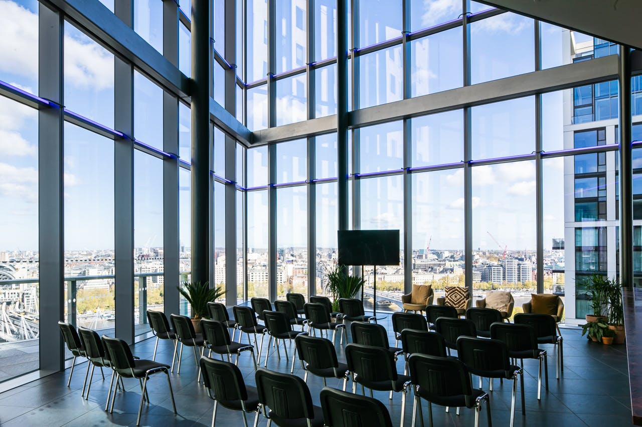 Modern event space with floor-to-ceiling windows, ideal for corporate meetings and workshops.