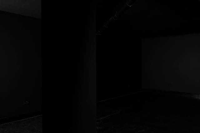 Minimalist dimly lit venue in Blackout studio for versatile events and gatherings.